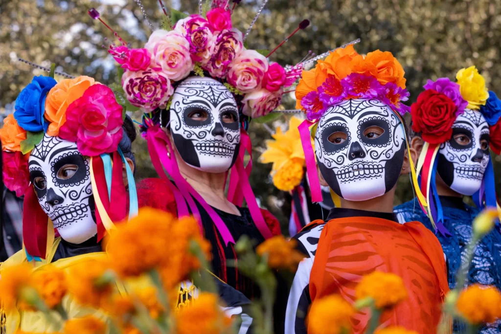Four women wearing traditional Dia de Los Muertos sugar skull masks participate at the famous Hispanic celebration.